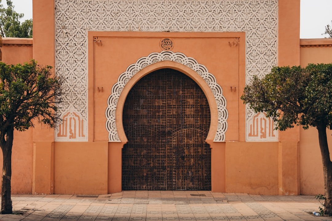 ornate-arched-doorway-with-intricate-white-patterns-and-trees-frnqfgot1hi
