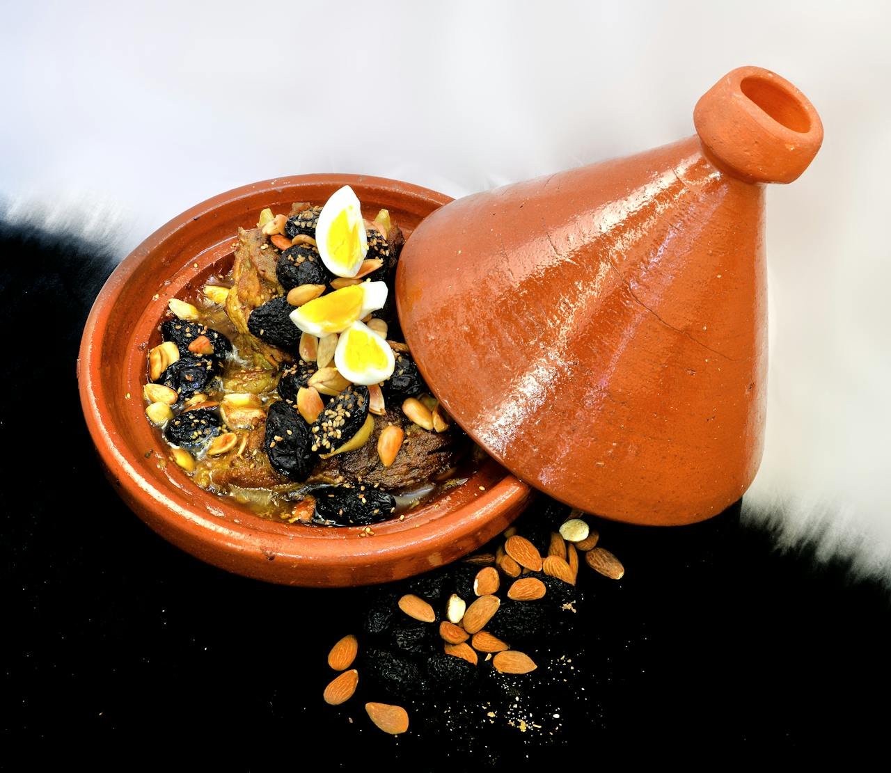 Mastering the First Impression: Your intriguing post title goes here Delicious Moroccan lamb tagine with almonds, prunes, and quail eggs in a clay pot.